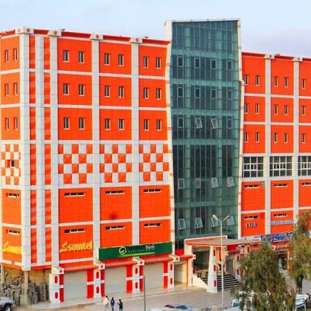 Corner of the facade showing the chequered panels and glazed stair tower