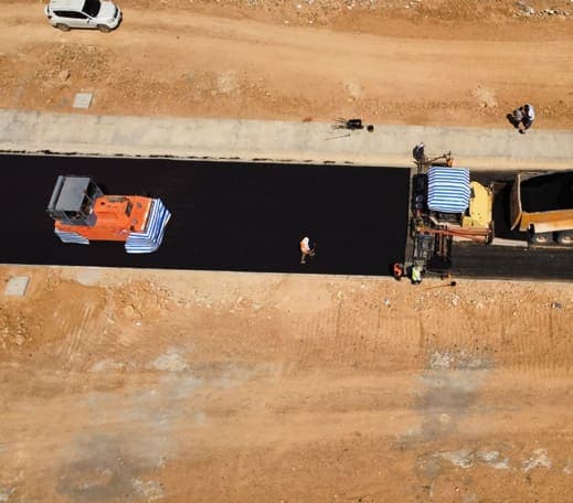 Fresh asphalt being rolled, seen from above
