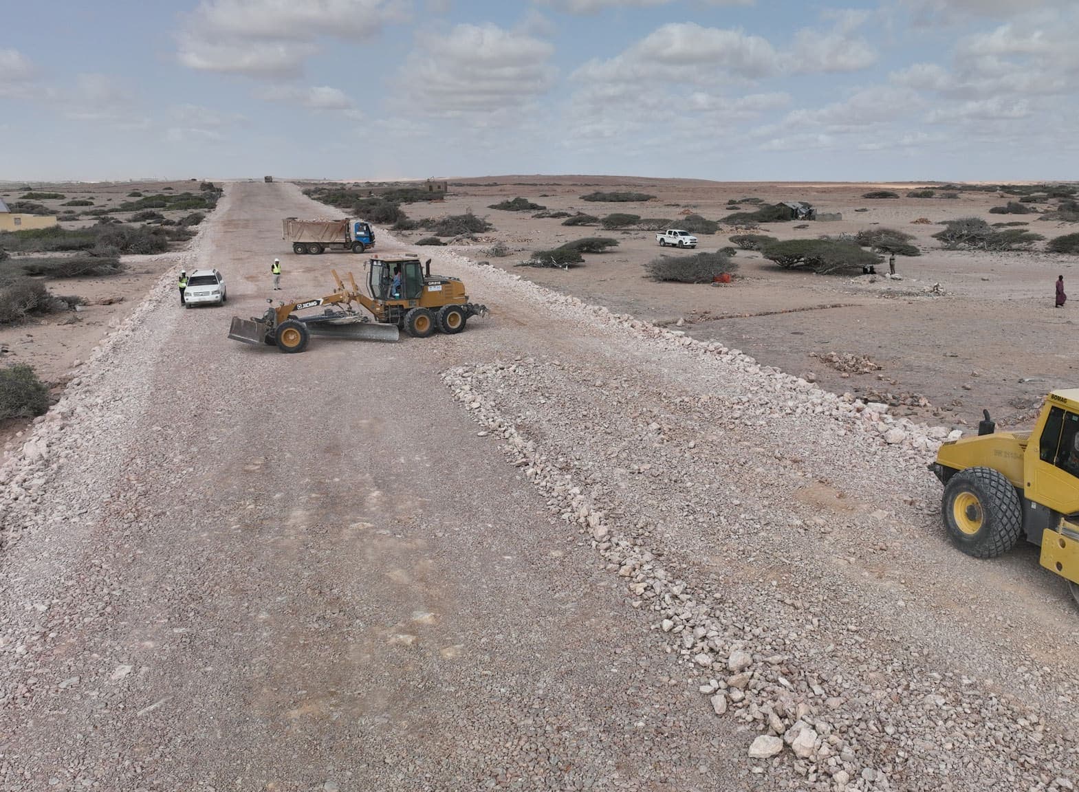 Motor grader and roller shaping the road base