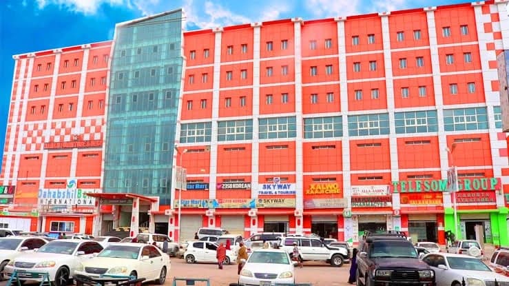 Street front of the Hargeisa Theatre Business Centre, with its orange-and-white facade, glazed central tower and ground-floor shops