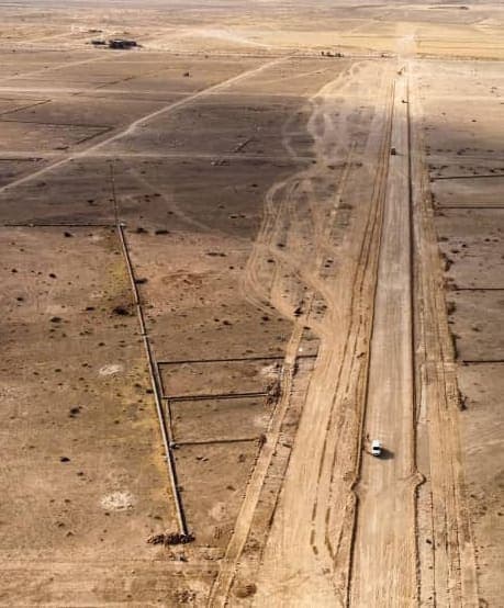 Aerial view of a graded road alignment set out across flat terrain